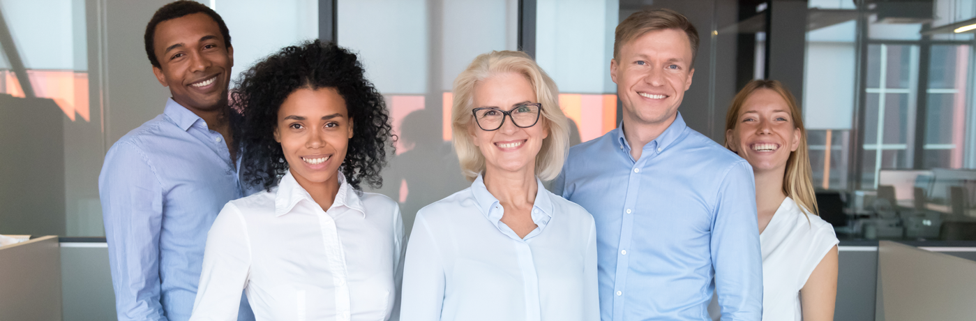 A group of five business people smile at the camera.