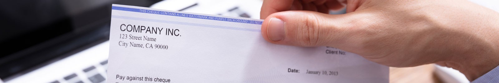 Image of hand removing paycheck from envelope.