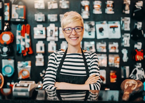 Store owner posing in front of a wall of products. 