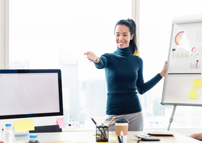 A young Asian woman leads a training for her colleagues.