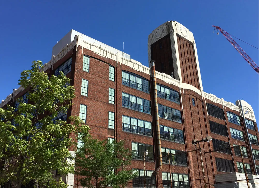The Studebaker Building against the blue sky with a red crane in the background.