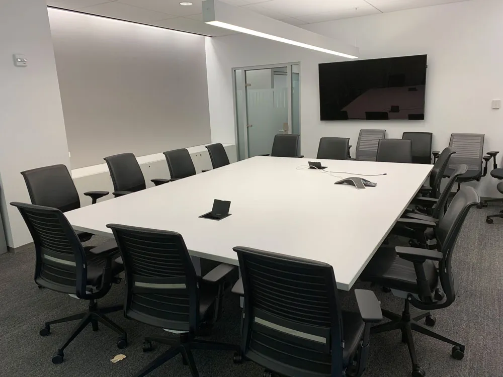 Modern conference room, with a monitor screen at the far end.
