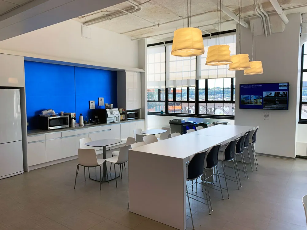 Kitchen with large windows, and a blue backsplash.